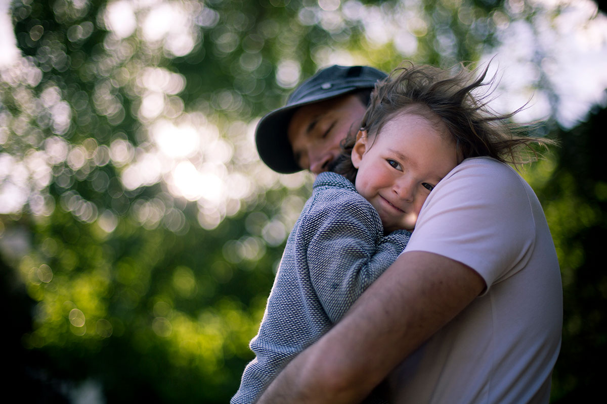 En ung liten tjej kramar sin pappa i famnen